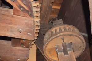 Bees waxed cogs and gears convert the windmills vane motion to a circular motion of the grinding wheel