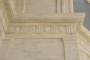 The friezes just below the ceilings of the Rotunda and Legislative Foyers have a repeating pattern of five carved symbols; an owl perched on a book in front of a man’s profile representing art and education; a bull with ears of corn framing its face representing agriculture; a round shield, peace pipe and tomahawk representing Native American lore, scales representing peace and justice; and the six sided shield with pickaxes representing mining and industry.
